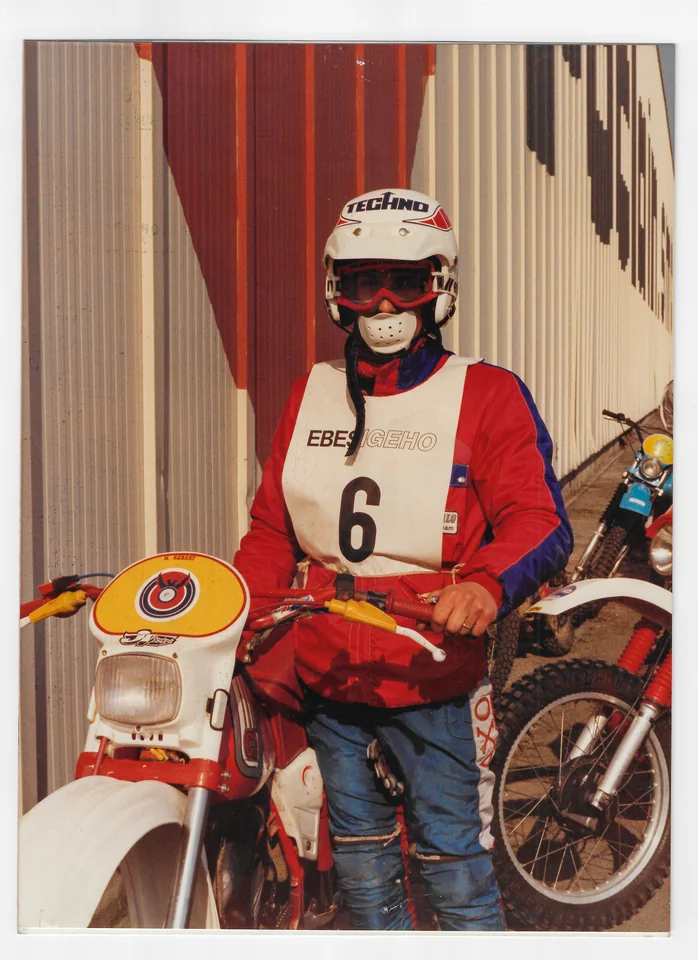 Photo d’archives d’Olivier en équipement rouge et bleu, avec un dossard 6, sur une moto d’enduro.