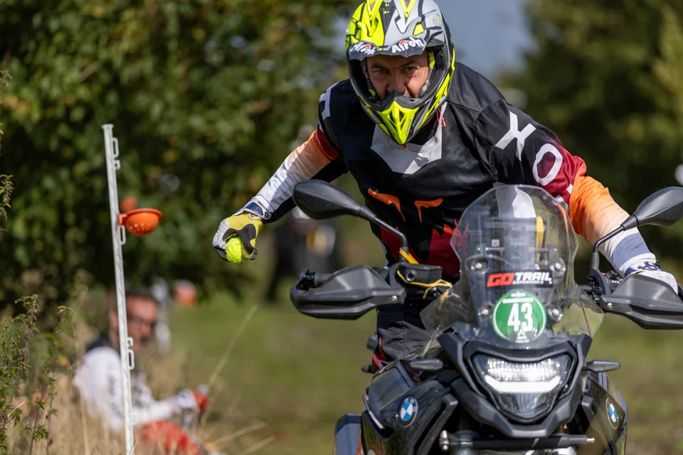 Un pilote au casque jaune roule vers l’appareil sur un trail CFMOTO.
